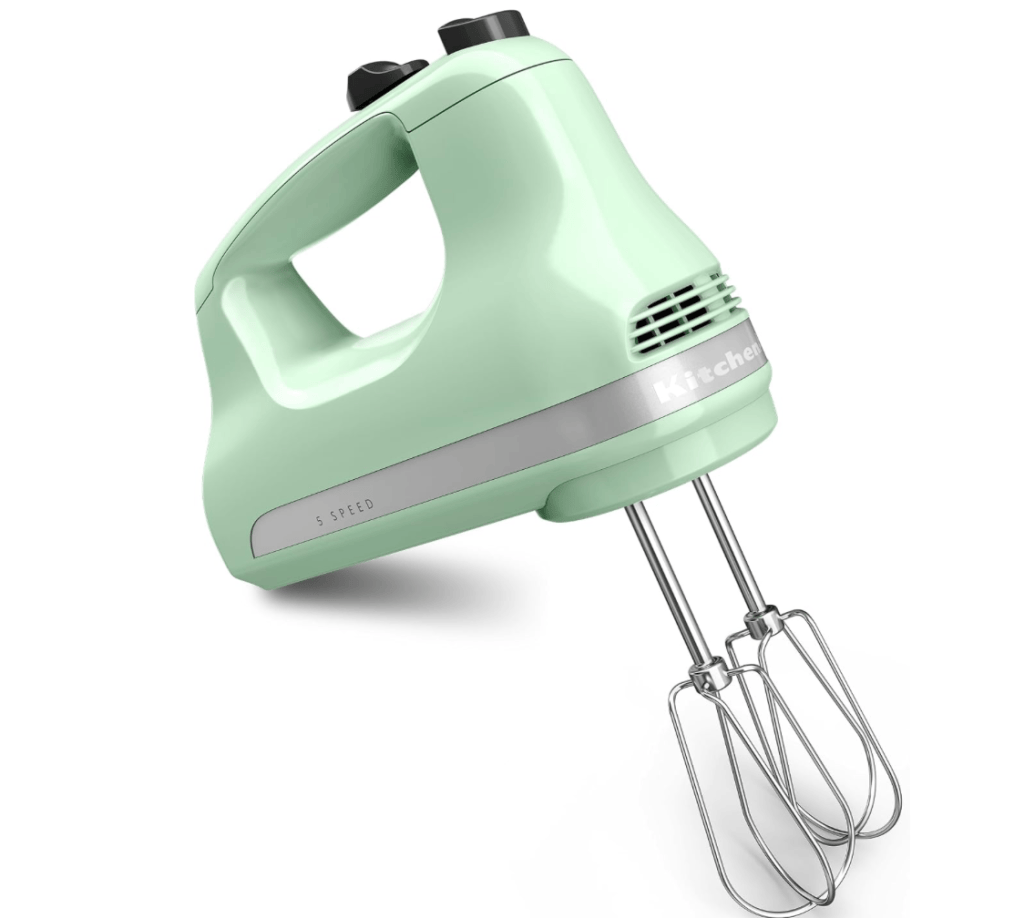A mint green electric hand mixer with five speed settings and stainless steel beaters.