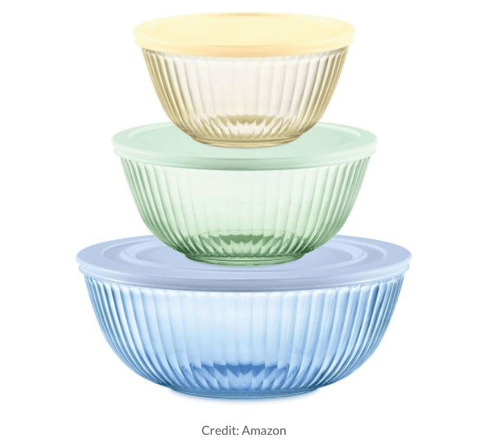 A stack of three glass bowls in pastel colors: yellow, green, and blue, with matching lids on the top two bowls.